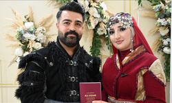 Bir çift nikah masasına geleneksel kıyafetlerle oturdu
