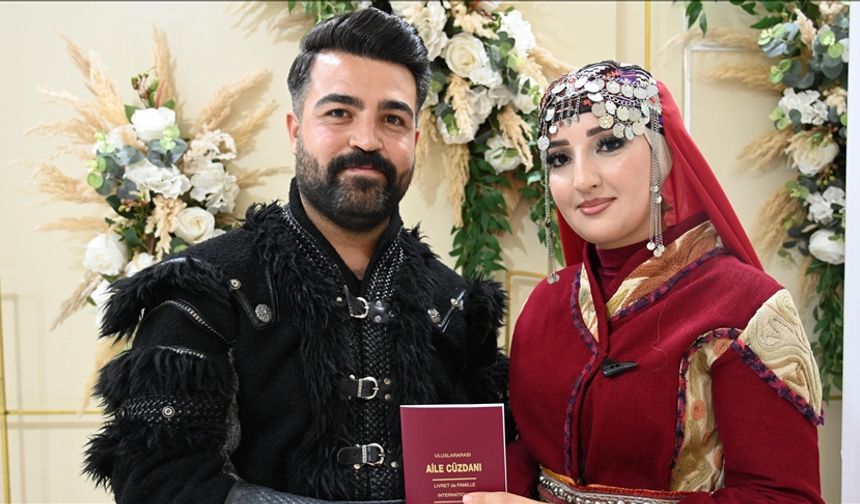 Bir çift nikah masasına geleneksel kıyafetlerle oturdu